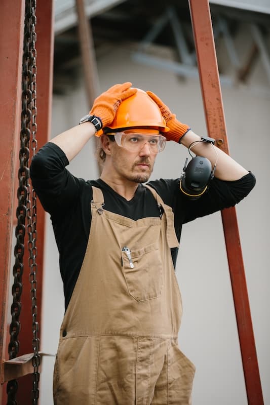 Construction worker adjusting his helmet