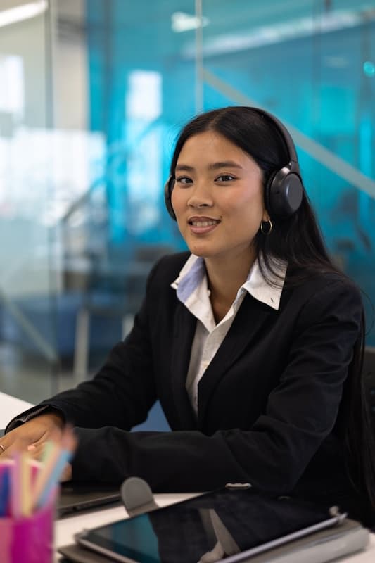 A corporate receptionist smiling and wearing a headset
