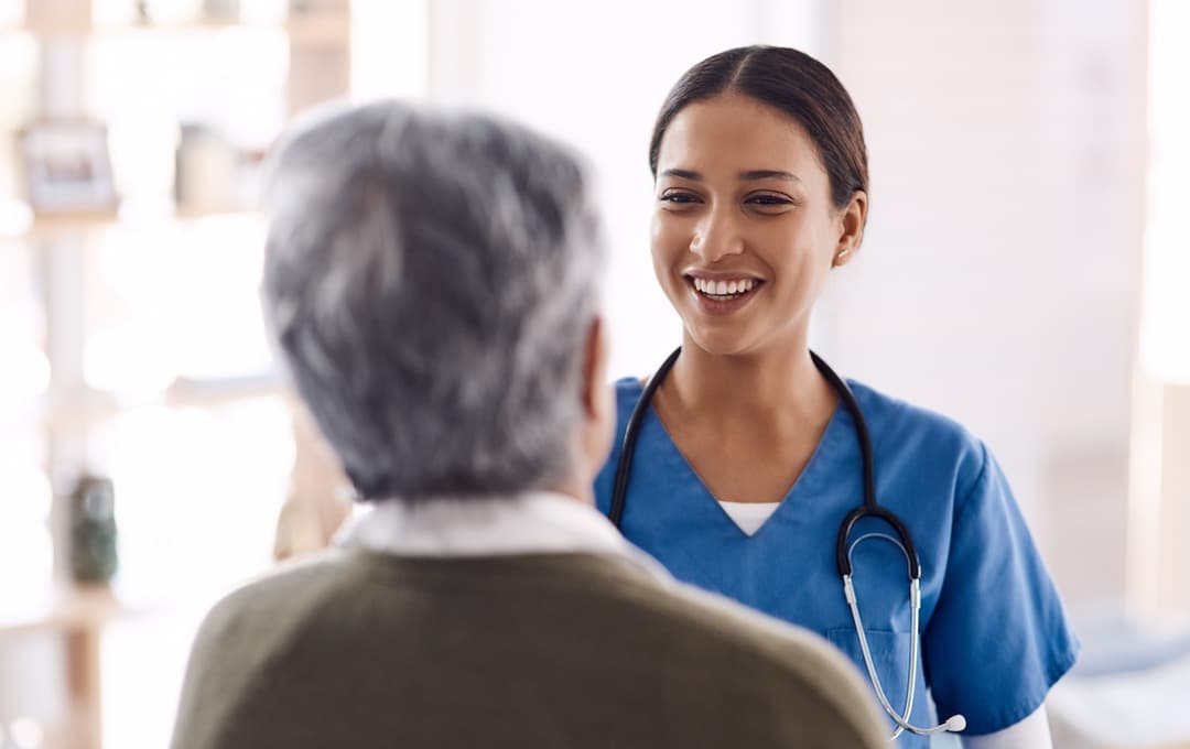 A smiling aged care female doctor with an elderly patient
