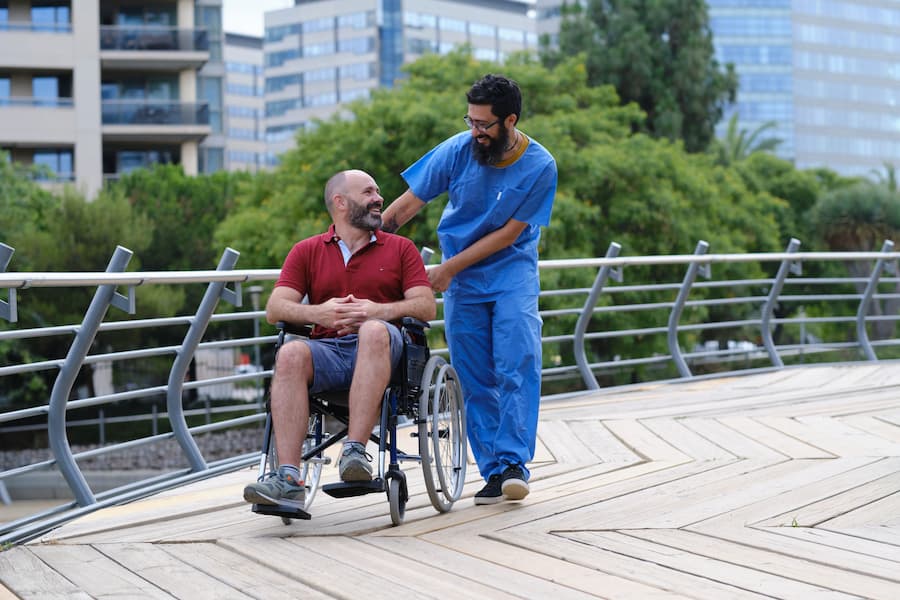Man in Wheelchair with Healthcare Worker Outside