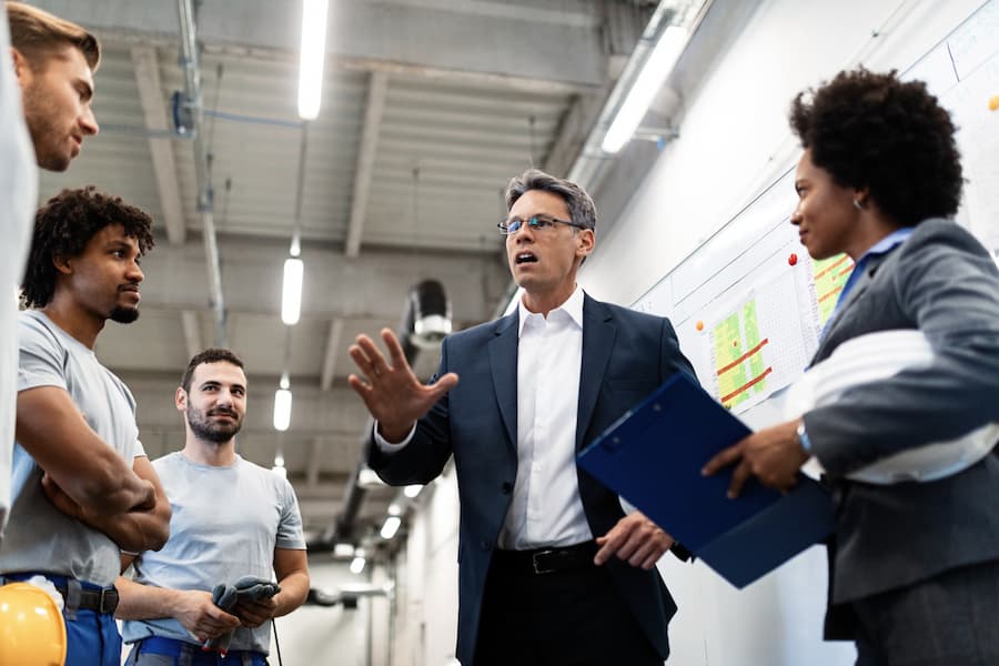 Company leader talking to employees in a factory