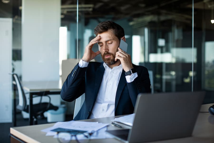 Worried Man on Phone in Modern Office