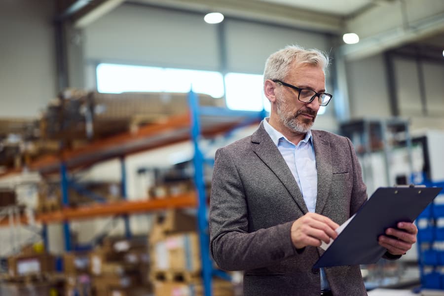Logistics manager reviewing documents in a warehouse