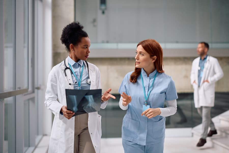 Female doctor and nurse talking in a hospital's hallway