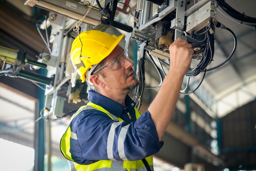Engineer Inspecting Automated Machinery in Factory Setting