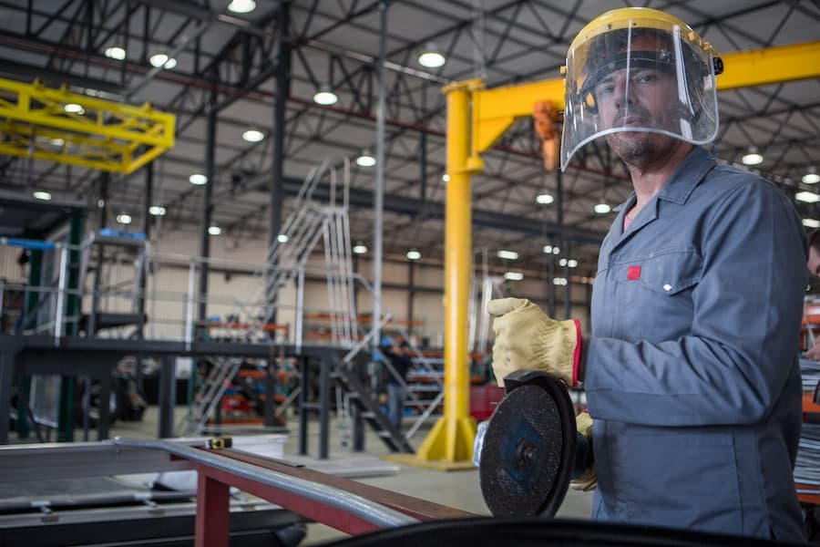 Factory worker in truck manufacture using buzz saw