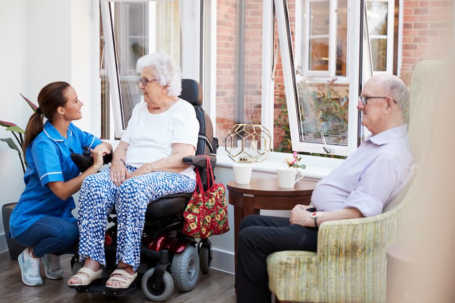 Aged care nurse assisting senior woman