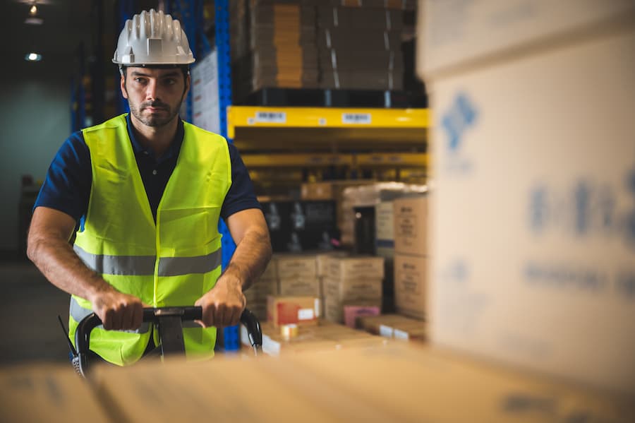 Male warehouse worker moving boxes