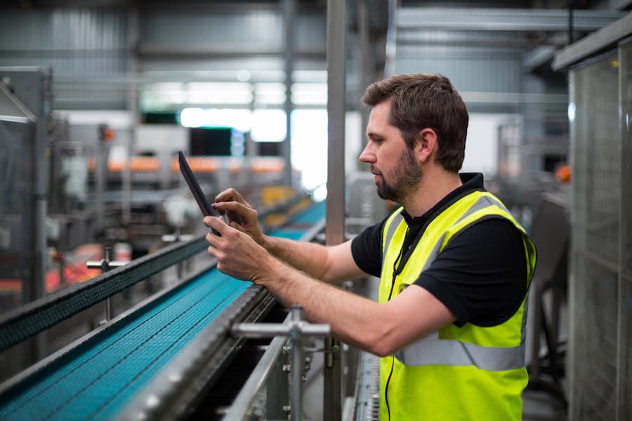 Attentive Factory Worker Using A Digital Tablet In Factory