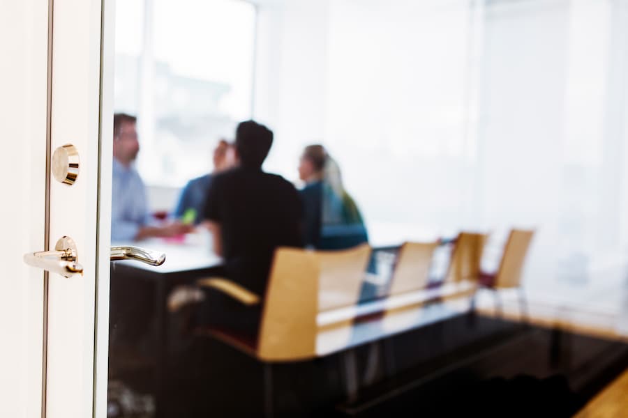 Blurred Office Meeting Seen Through Open Doorway