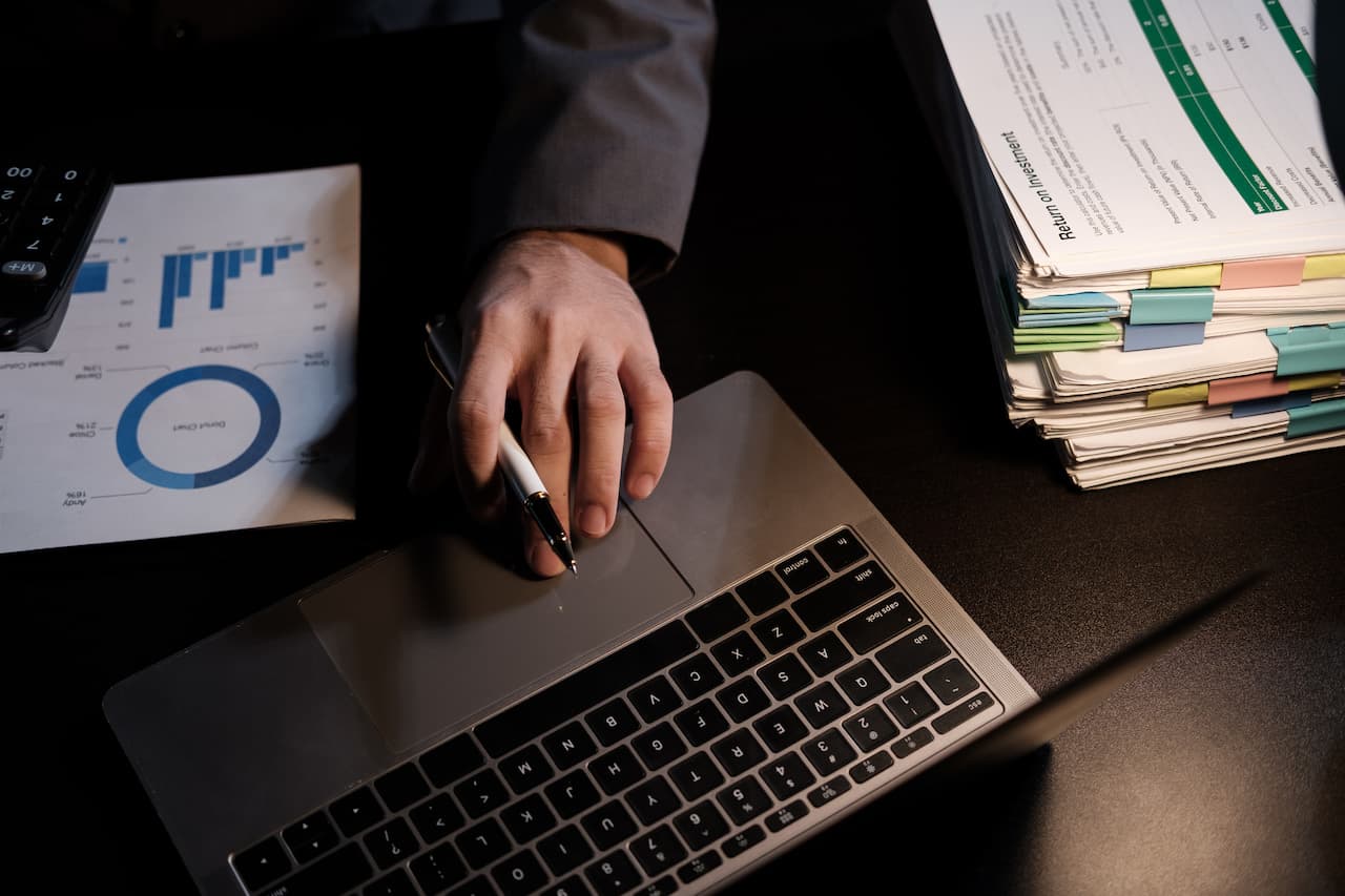 Accounts Receivable Officer working on laptop and documents