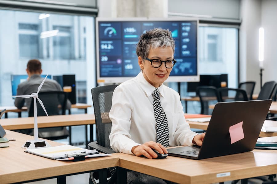 Businesswoman working on laptop in modern office environment, showcasing productivity and innovation