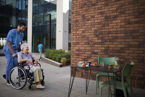 Caregiver having breakfast with his client at cafe.