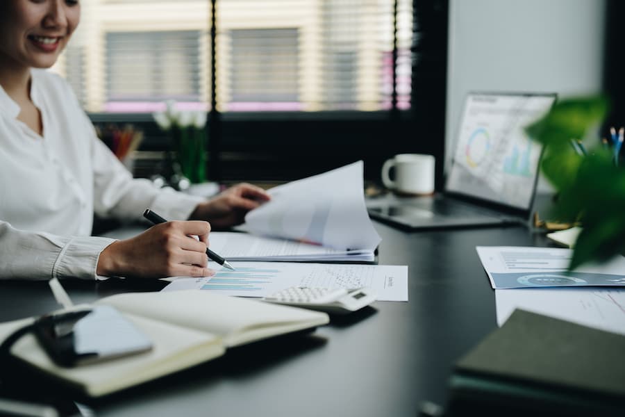 Close up business asian woman working with financial and business report and calculator
