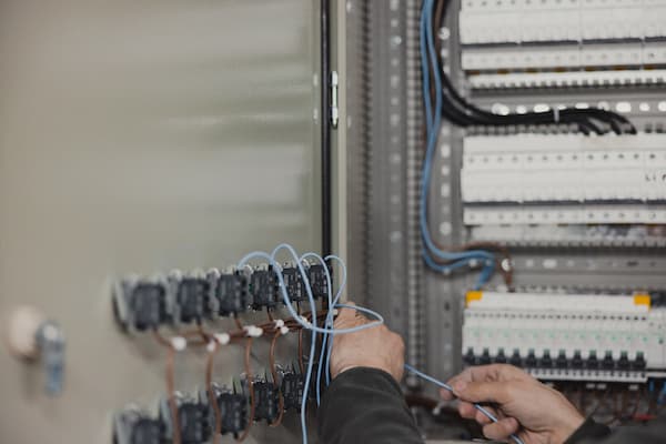Close-up of electrician hands working on switches in control room