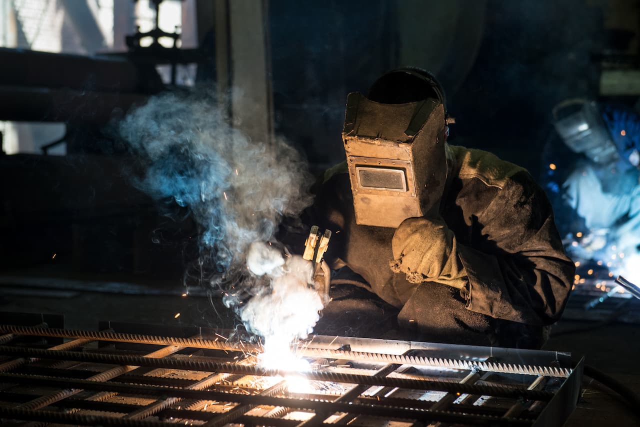 Closeup worker in a mask doing the welding in a workshop