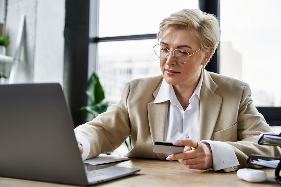 Female credit controller using Laptop and Credit Card in Office