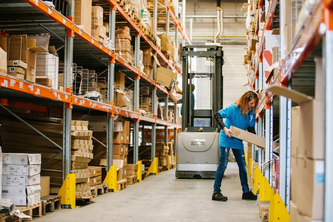 Woman Working in Distribution Warehouse Moving Boxes