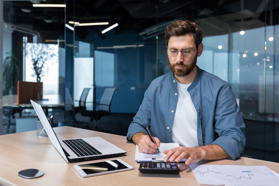 Serious and focused financier accountant on paper work inside office,