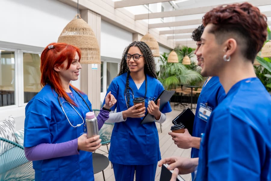 Group of Healthcare Students in Blue Scrubs Having a Coffee Break