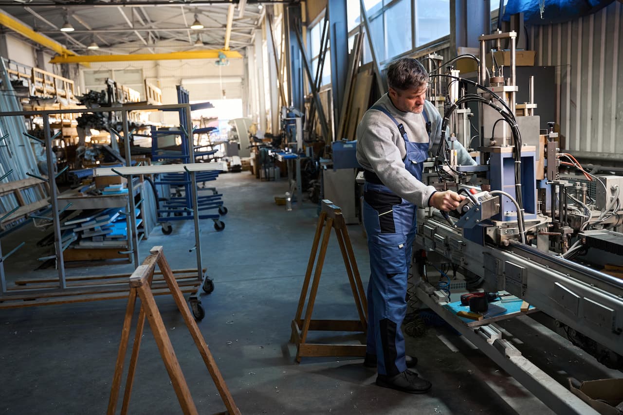 Handyman working at factory for aluminum and PVC windows production