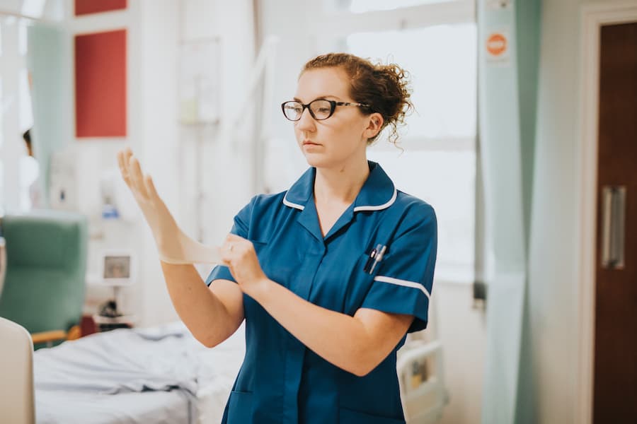 Healthcare Professional Prepares for Duty in Hospital Ward