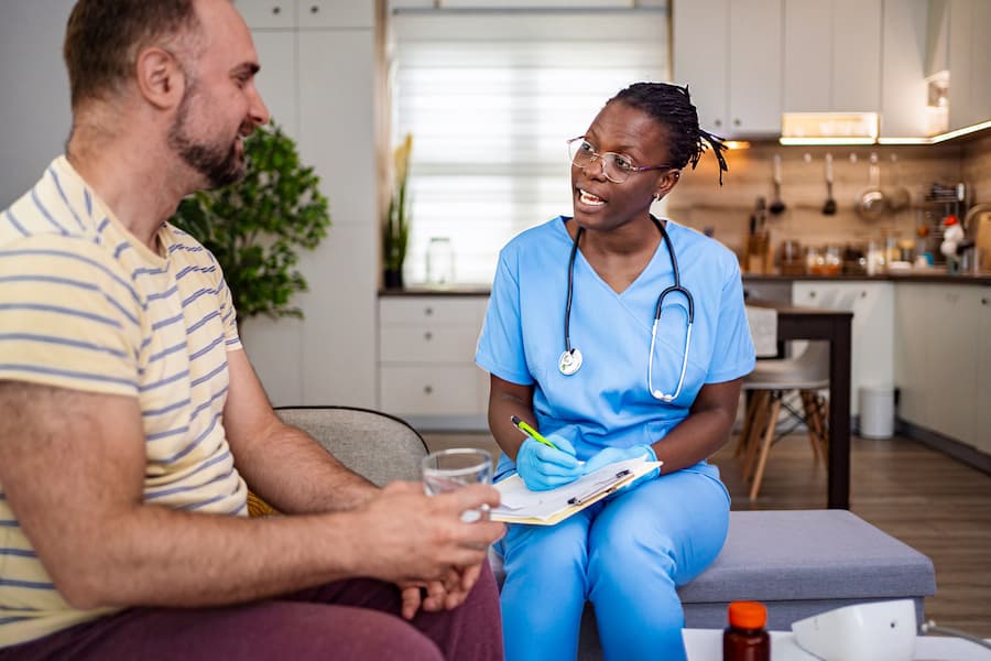 Healthcare Worker Talking With Man at Home