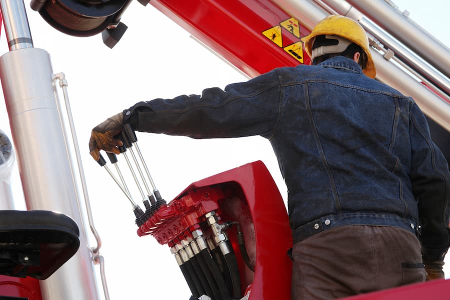 Heavy Equipment Operator Using Controls on Red Machine