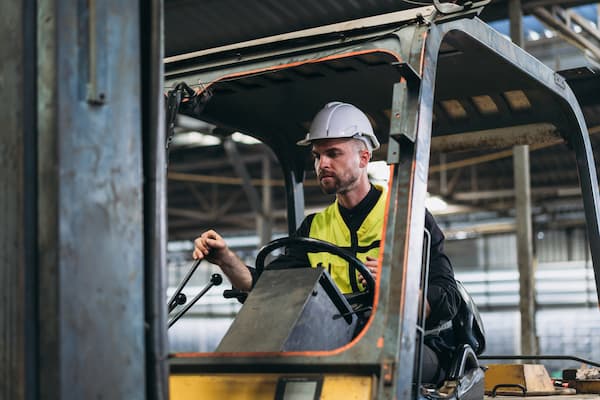 Industrious Engineer Operating Forklift in Warehouse. Efficient Forklift Driving in Factory.