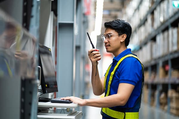 Inventory controller with walkie talkie in warehouse