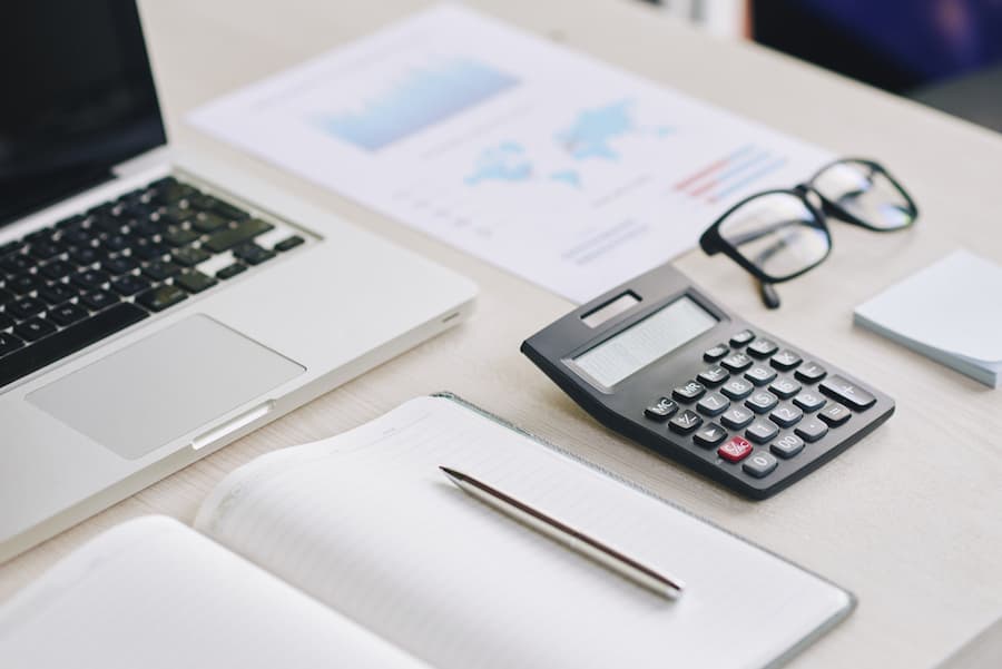 Laptop, Calculator, and Business Documents on Desk