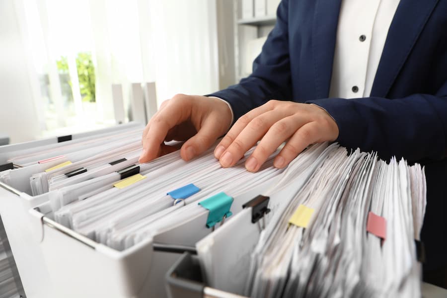 Man Organizing Files in Office Storage Container