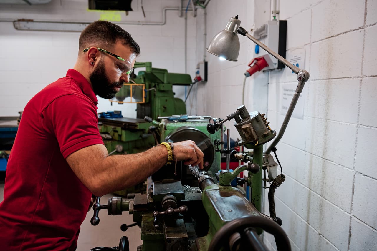 Man Working with a Lathe Machine in a Workshop