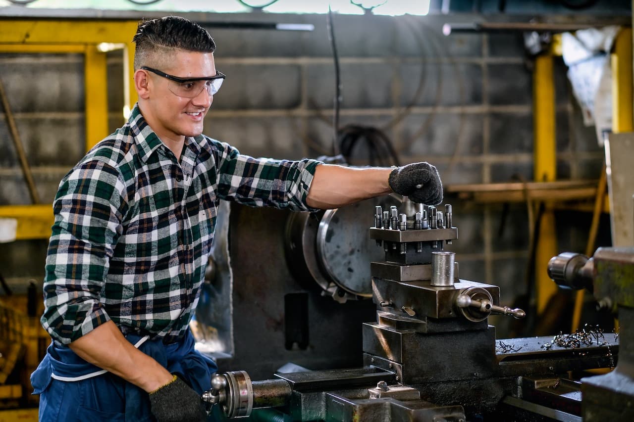 Man Working with Metalworking Equipment in a Factory
