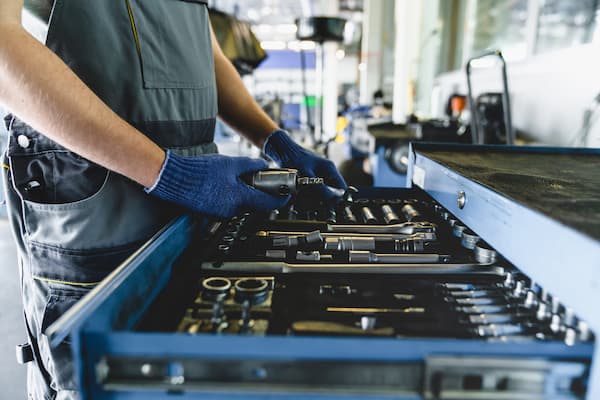 Mechanic with Tools Inspecting a Toolbox in Garage