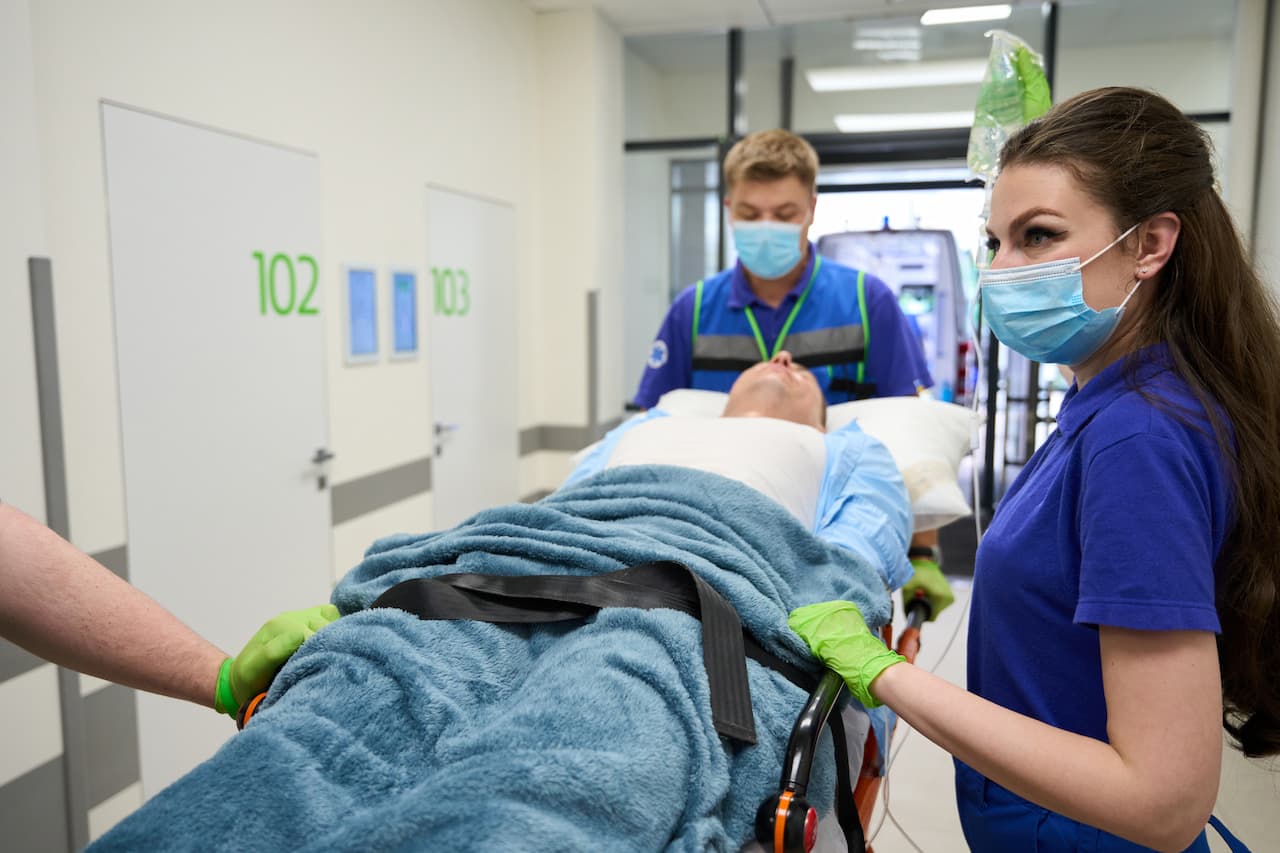 Medical Staff Moving Patient on Gurney in Hospital