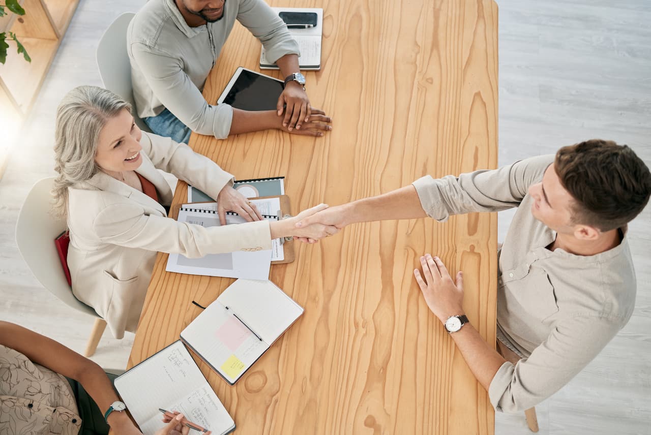 Top view, meeting and handshake of business people in office.