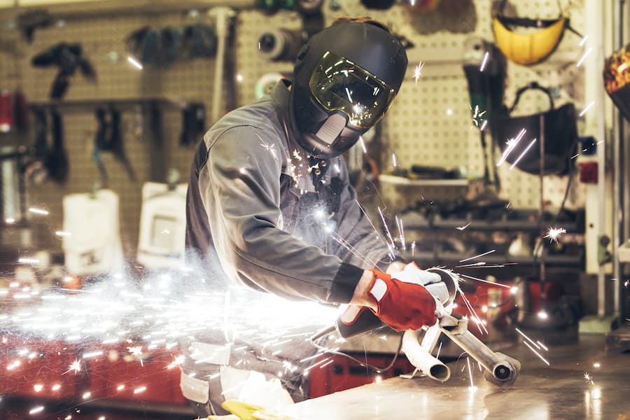 Metal Worker Grinding Metal with Sparks in a workshop