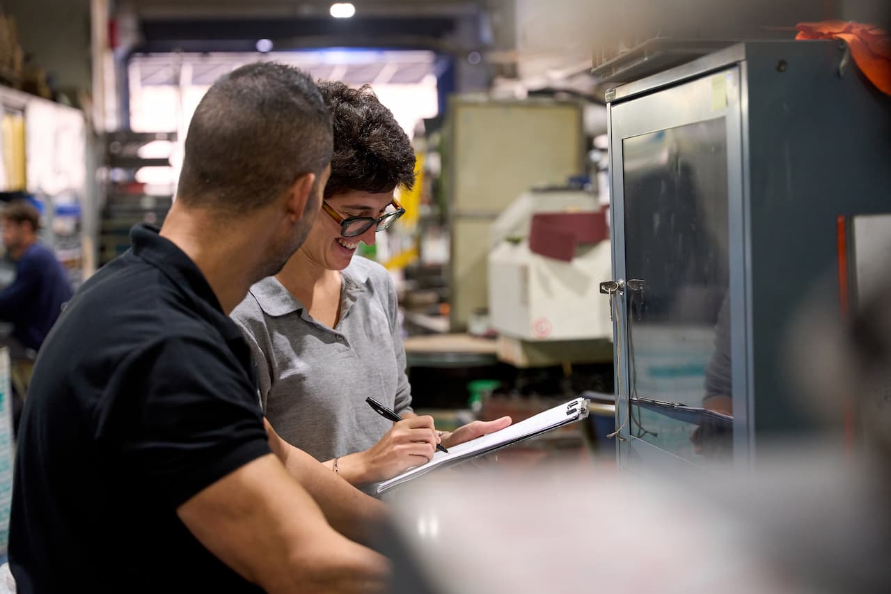 Metallurgy workers optimizing production process in steel mill