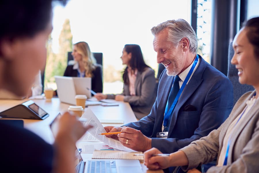Multi-Cultural Business Team Meeting And Collaborating Around Table In Modern Office Building