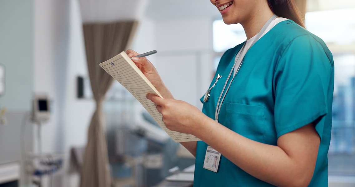 Female Nurse writing in folder in hospital