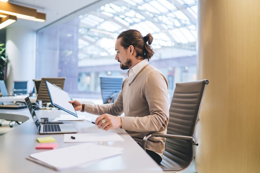 pensive male office worker holding planner pondering on publication and article