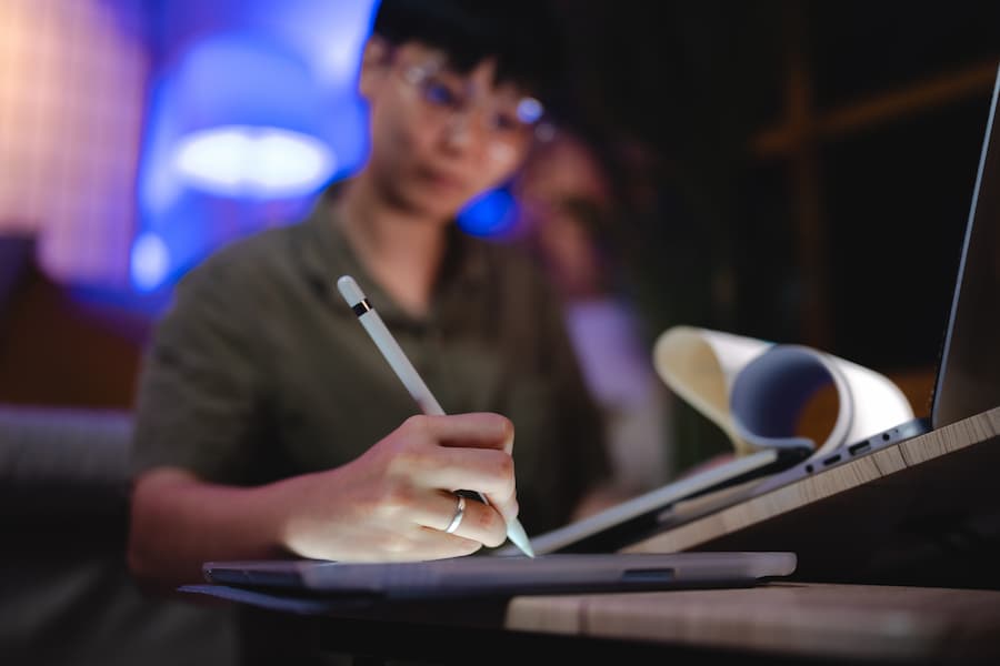 Person Using Tablet with Stylus at Night Indoors