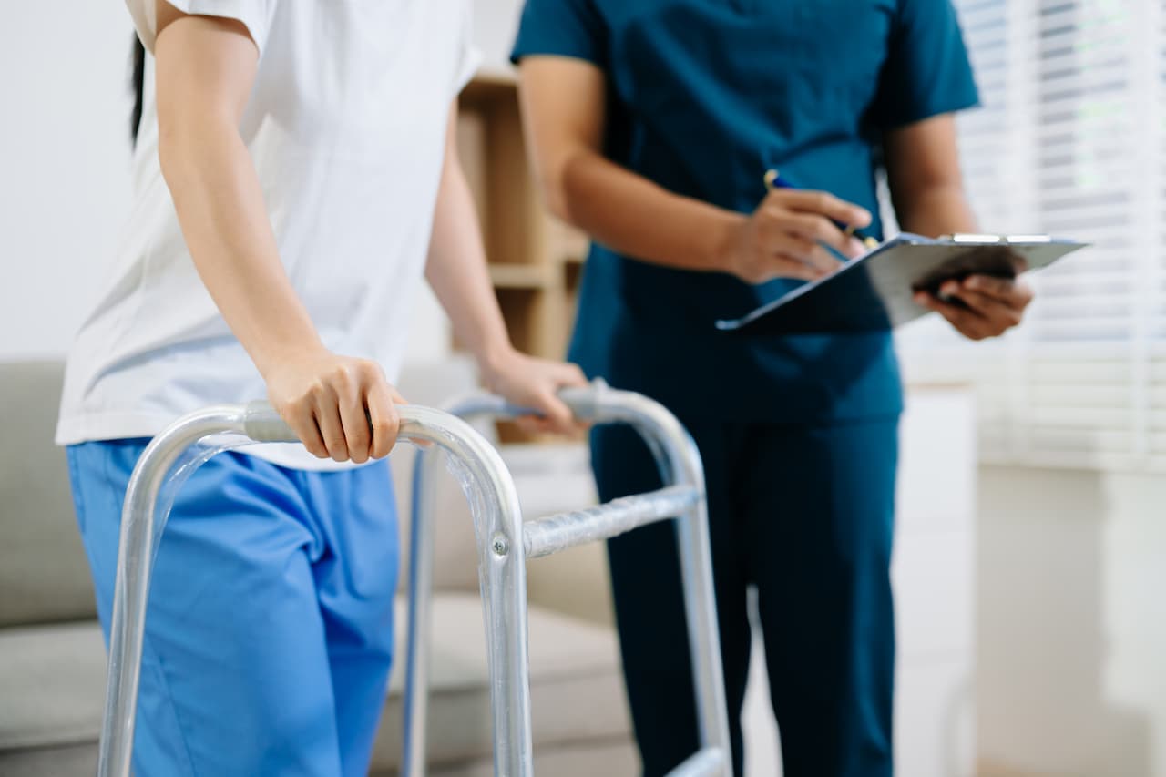 Physical Therapist Assisting with Walker at Rehabilitation Clinic
