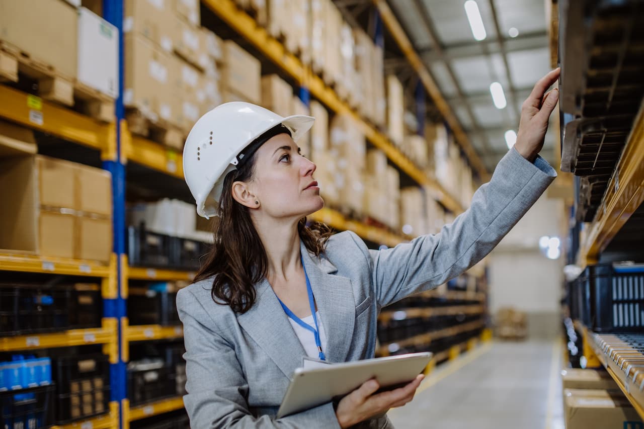 Woman Inspecting Inventory in a Large Warehouse
