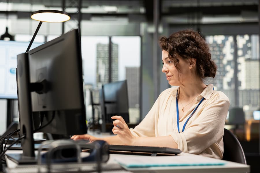 Professional Woman Works At Computer In Open Office