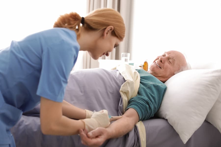 Senior Man Receiving Medical Care in Hospital Bed