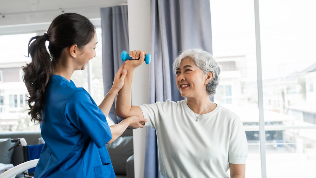 Senior Woman Exercising with Therapist in Bright Room