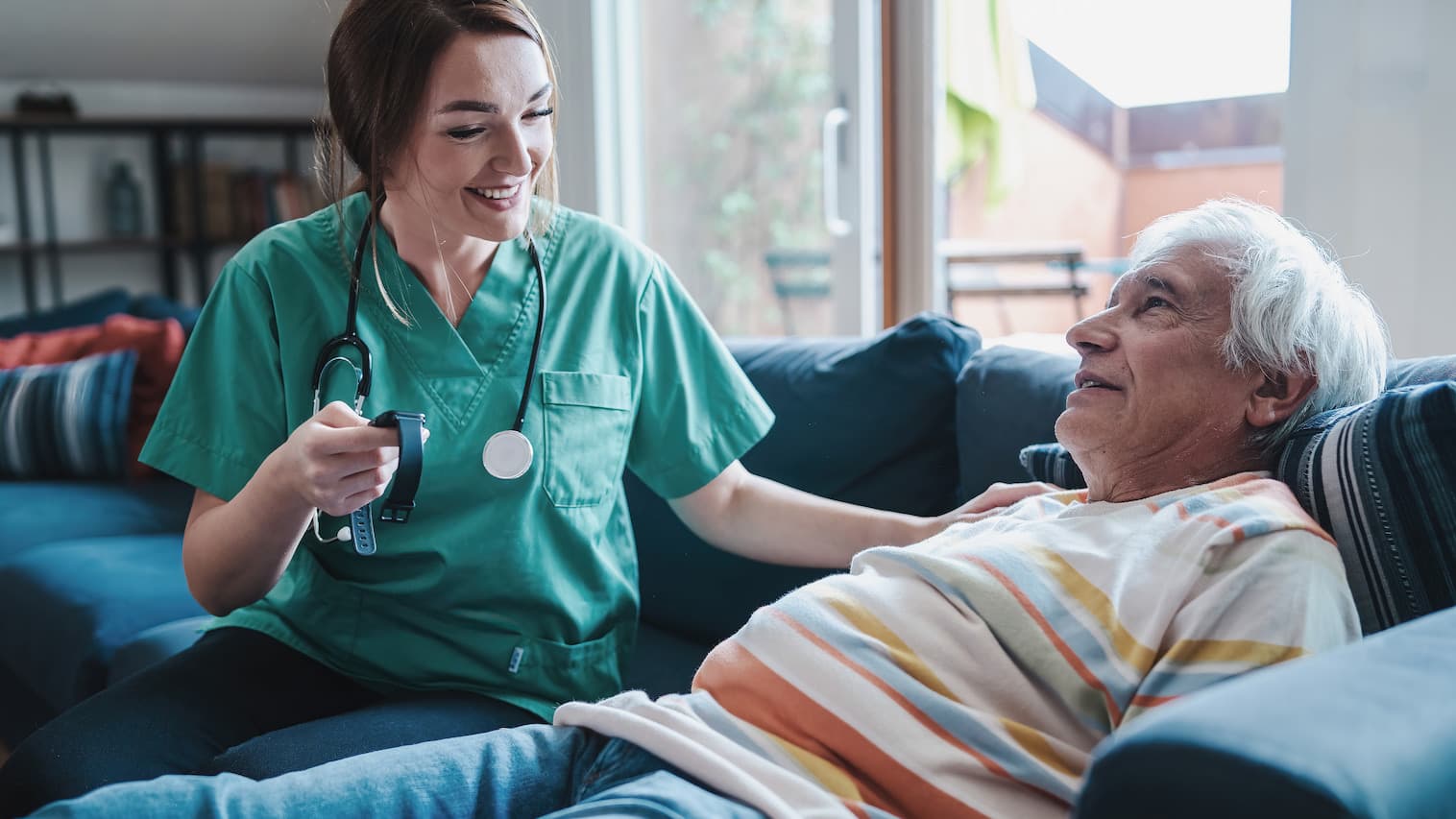 Smiling Nurse Helping Senior Man on Couch