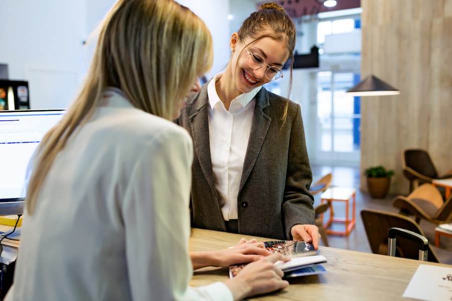 Smiling Young Woman Helping a Customer in Lobby